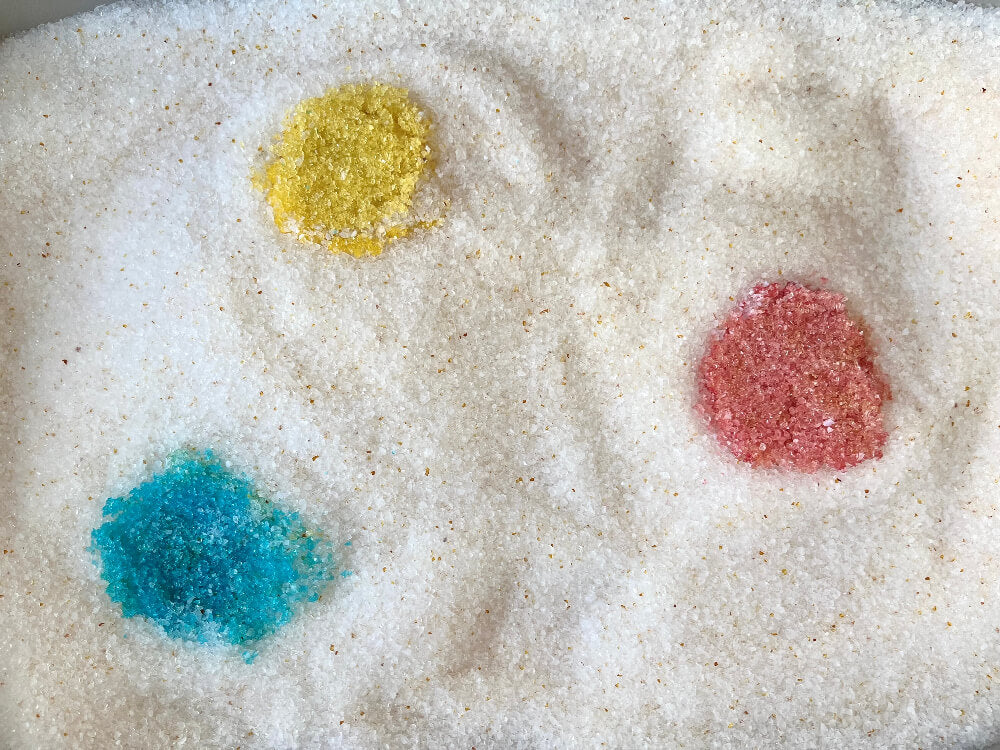 Pacha crystals in the tray, showing amber, red and blue-green colour spots